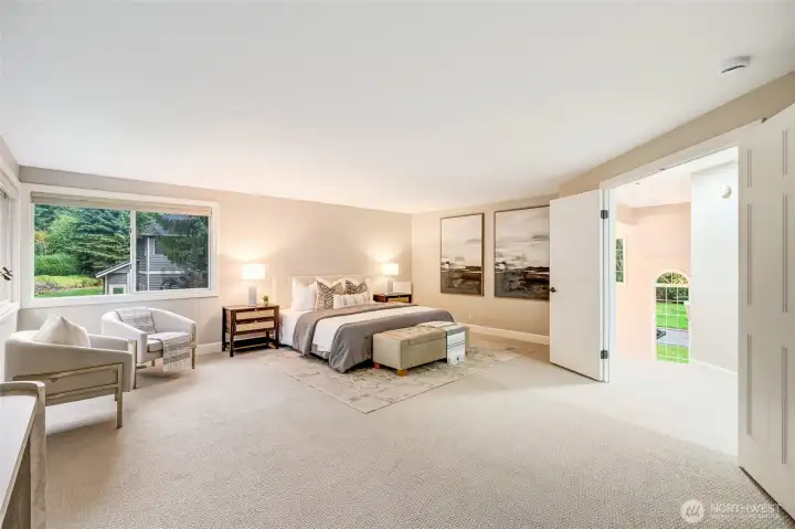 Upstairs, the indulgent primary suite is a true sanctuary. French doors open to a serene retreat with space for a full king set and a cozy sitting area. Expansive corner windows frame views of the meticulously landscaped backyard, filling the room with soft, natural light.
