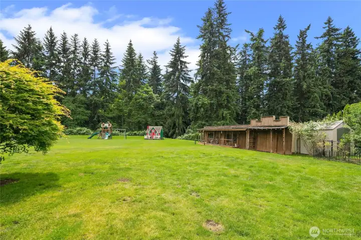 Sprawling lawns and gardens with old west style storage sheds conveniently located in rear yard.