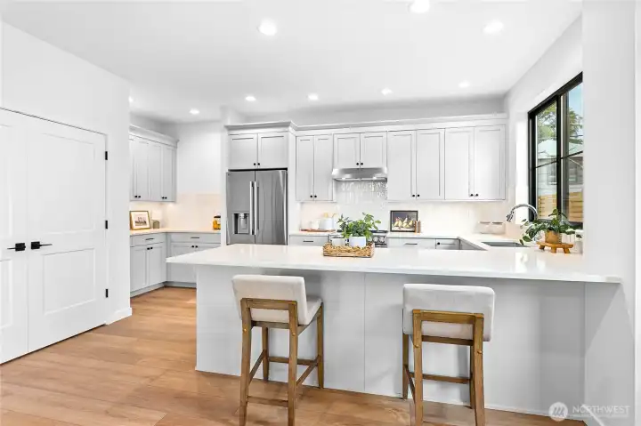 Everything you’d expect from a Janzen Custom Builders home! Gorgeous quartz counters, a spacious pantry, stainless steel appliances, and undercabinet lighting make this kitchen as functional as it is beautiful.