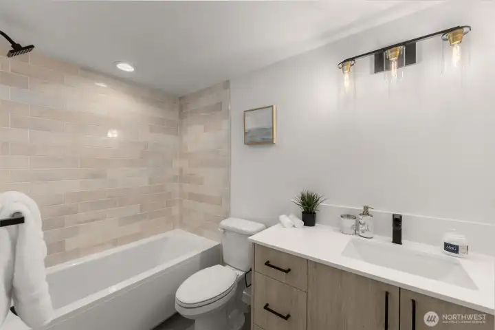 Sleek full bath with modern tile and a deep tub for ultimate relaxation.