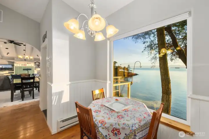 Charming breakfast nook framed by picture windows offering peaceful shoreline views—perfect for morning coffee by the sea.