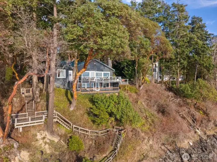 Private stairway meanders through native landscape to the shoreline below, enhancing the property’s connection to the water.