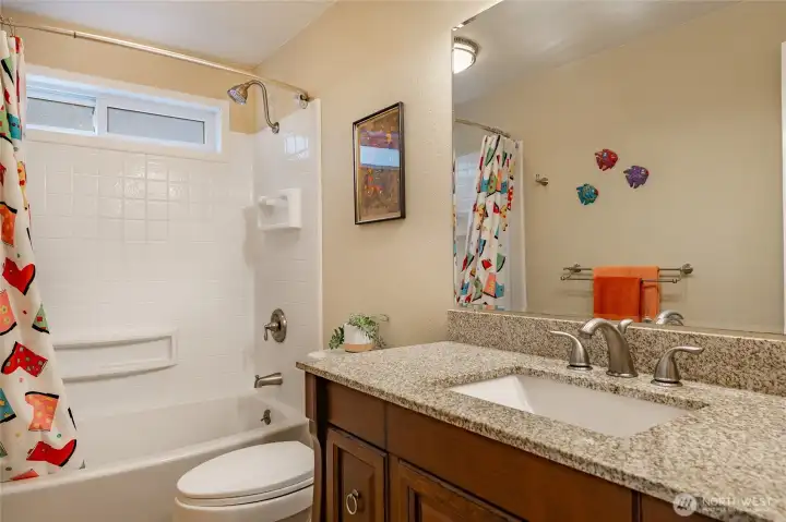 Full hall bath for two main level guest rooms with radiant heated flooring