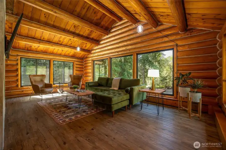 Vaulted ceilings, floor-to-ceiling stone fireplace, and expansive picture windows create a warm gathering space after a day on the slopes or trails.