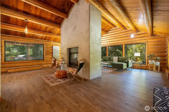 Dining and Living Room with vaulted ceilings, large picture windows and floor to ceiling fireplace.