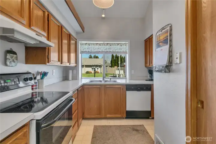 The functional kitchen has ample cabinetry and workspace. The utility room is just to the right.