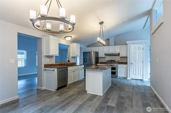 Absolutely stunning kitchen! To the left is the family room with covered patio access and to the right is the formal living space.