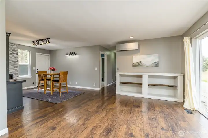 Versatile flex space adjacent to the kitchen, featuring a cozy sitting area with a fireplace and mini-bar—perfect for entertaining with seamless access to the deck