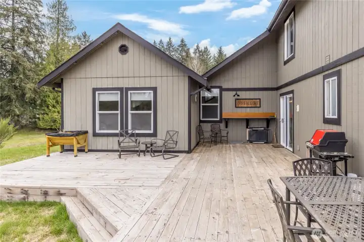 Step out onto the expansive deck, custom-built from timber harvested right on the property, offering a private view of your one-acre sanctuary