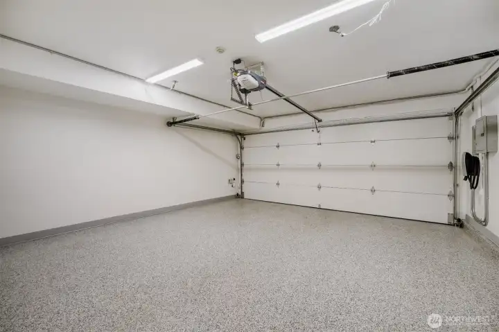 The two-car garage is genuinely exceptional, featuring an epoxy-finished floor, reinforced and insulated garage doors, Tesla charging unit, and easy alley access.