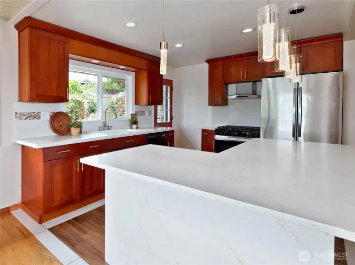 Cherry cabinets, Quartz counter tops, Stainless steel appliances and gas stove.