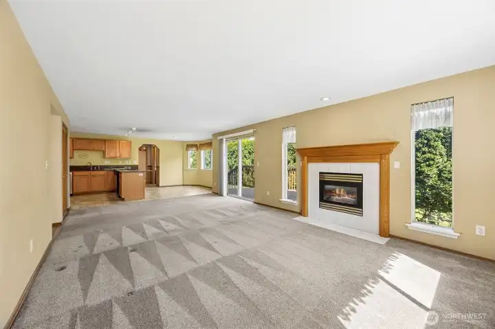 Inviting family room features a cozy gas fireplace and abundant natural light, creating a warm and welcoming space to relax or gather.