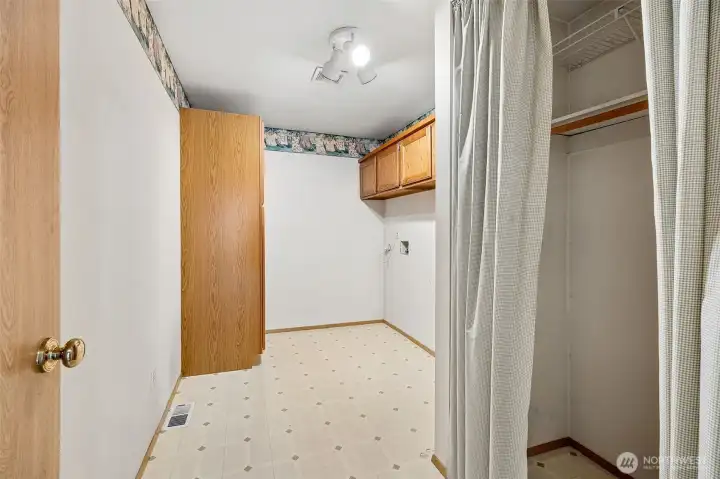 Laundry room + storage closet just past the kitchen. Natural gas hot water tank was replaced in 2023.