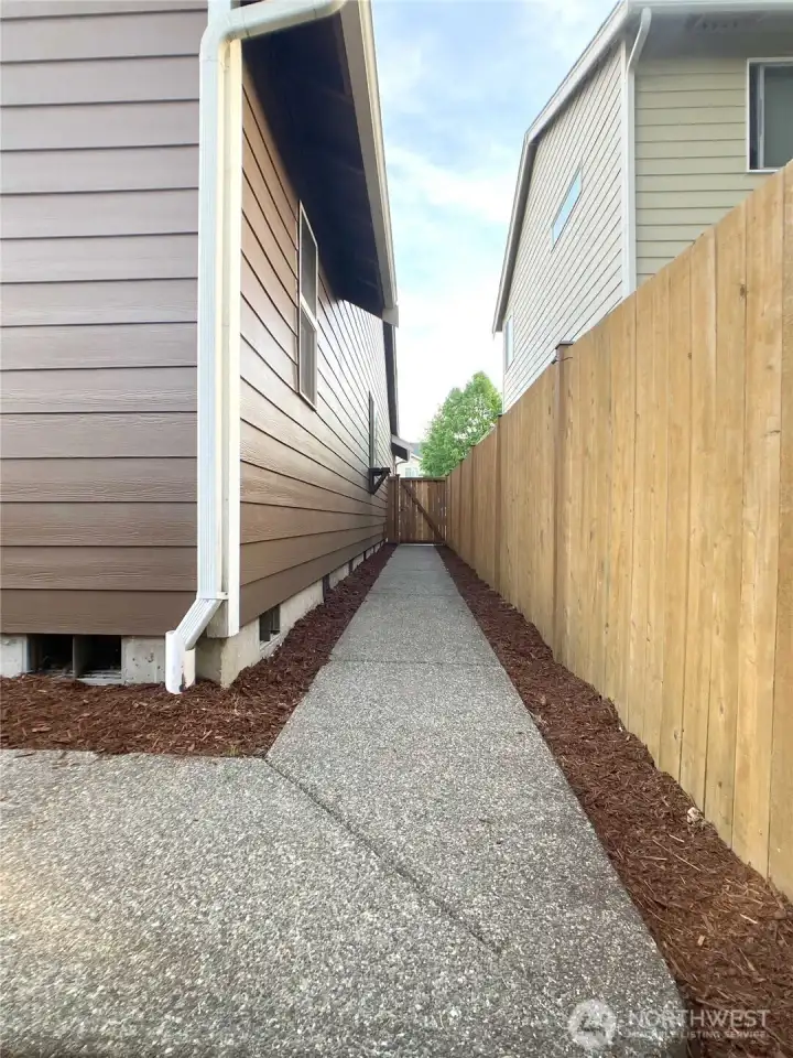 Sidewalk connects the driveway and the back yard