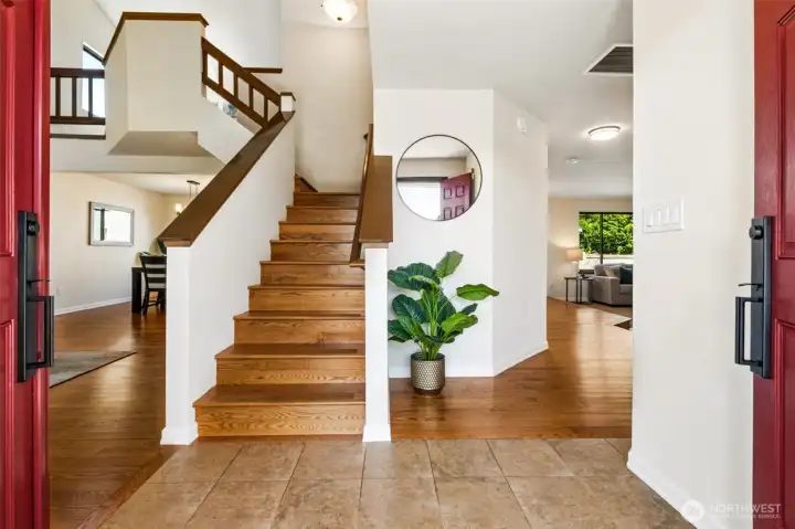 Tile entry transitions to beautiful hardwood flooring, complemented by an open staircase and abundant natural light