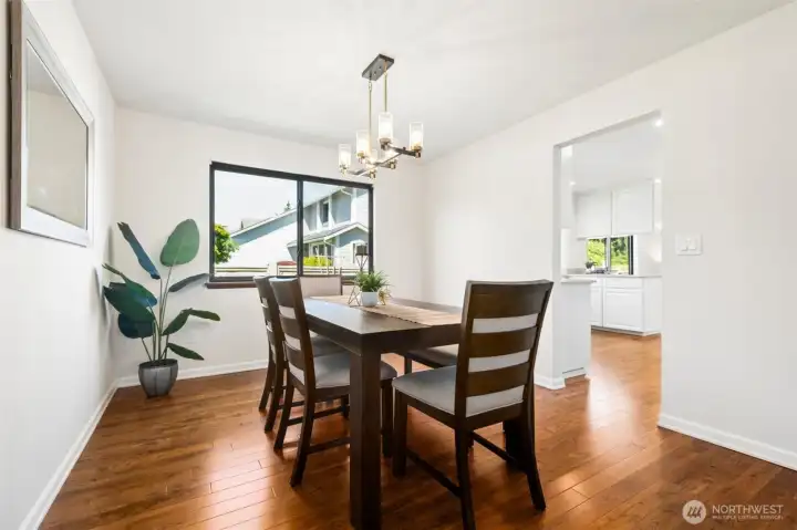 Gather family and friends in the bright formal dining room, highlighted by hardwood floors, abundant natural light, and a contemporary light fixture.