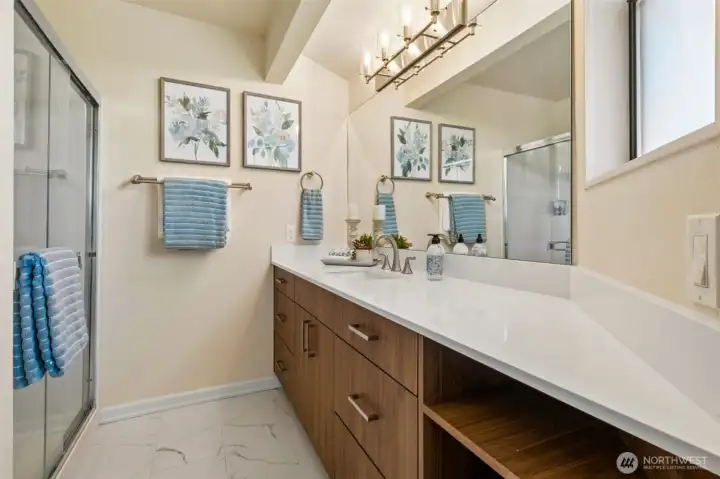 The primary suite is complemented by a beautifully updated ensuite bath featuring stylish finishes, modern fixtures, and timeless appeal. - Love the added counter & storage space!