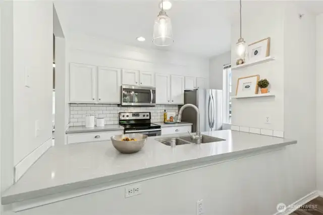 Redone kitchen with quartz counters, and subway tile.