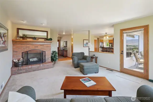 main level living area with fireplace and door to wrap around deck