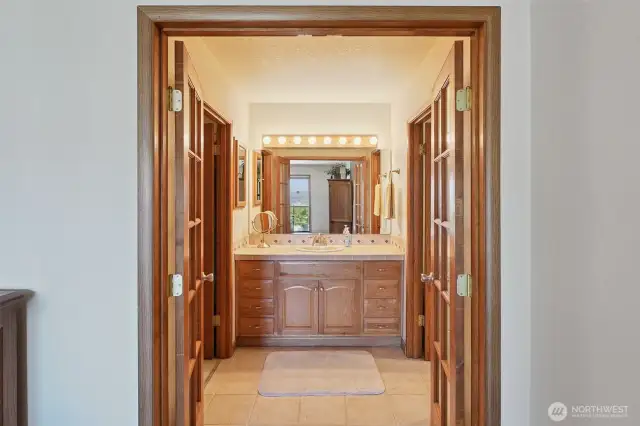 French doors in primary leads to bathroom and wardrobe closet