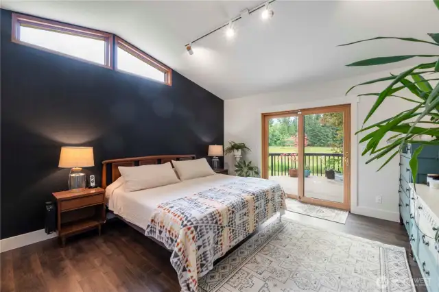 Located on the main floor, this primary bedroom is sure to please with plenty of natural light, vaulted ceilings, and private access to the back deck.