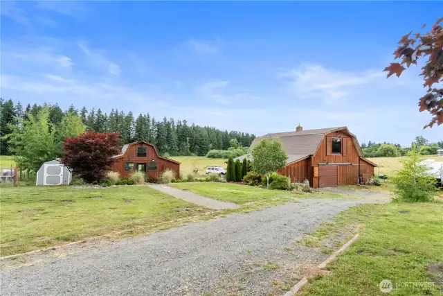 Situated along the circular driveway, the two modern barns are true highlights of this exceptional property! There are two RV hookups, one by the barn with power and water and one full up by the house with a separate 100-amp breaker for electric car charging.