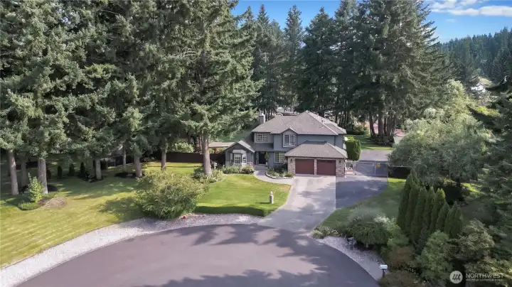 This beautifully landscaped property boasts a tranquil, woodsy setting, creating a peaceful and serene environment perfect for relaxation and enjoyment, with mature trees and well-maintained grounds.