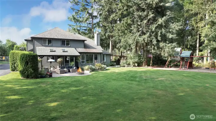Rear of home patio nicely landscaped back yard. The backyard offers a comfortable and inviting space for relaxation and outdoor activities, featuring well-maintained landscaping and a patio area perfect for entertaining or enjoying peaceful moments.