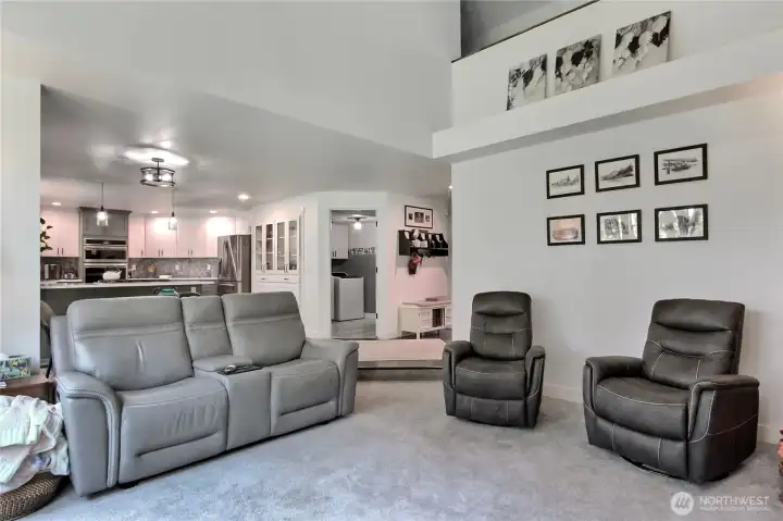 This image provides an alternative perspective of the Family Room, offering a clear view of the adjacent kitchen space. A key feature of this shot is the elegant and stylish lighting fixtures that enhance the ambiance of the kitchen area, creating a warm and inviting atmosphere.