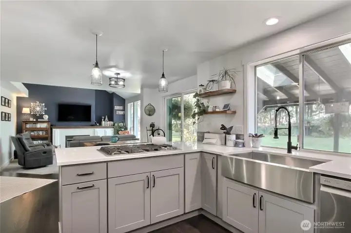 The kitchen features a charming one-bowl farmhouse sink that provides a delightful view of the backyard, enhancing the dining experience in this well-designed eating area.