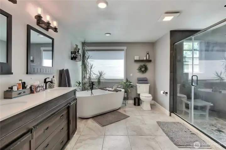 Spacious and luxurious Master Bathroom featuring a freestanding soaker tub, a refreshing walk-in shower, and a custom-designed vanity area, providing both comfort and elegance.
