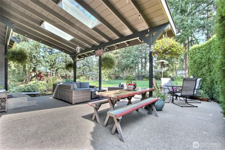 This beautifully designed covered deck is the ideal space for hosting memorable gatherings, offering a tranquil and private backyard setting. The deck boasts a thoughtfully crafted picnic area, perfect for casual meals and relaxed social time, complemented by a durable concrete patio, providing a versatile surface for outdoor activities and comfortable seating arrangements.