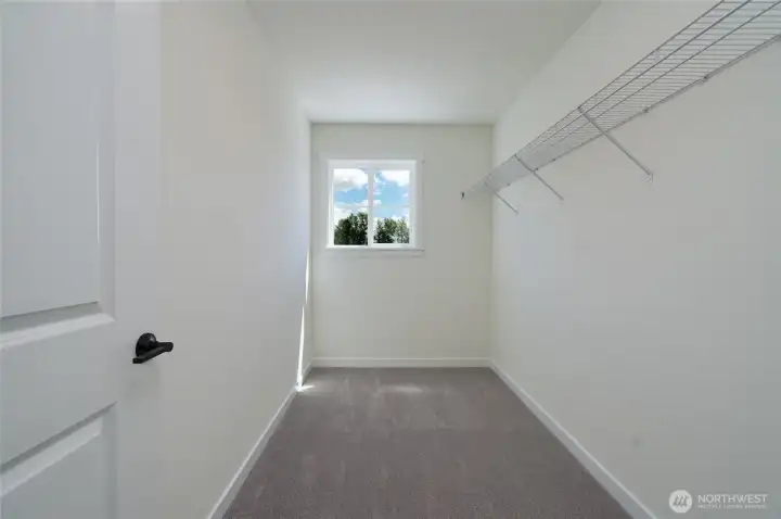 Upstairs Primary Walk-in Closet - Features and colors may differ.