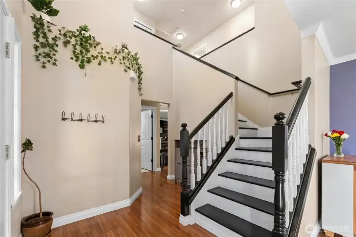 Entry features soaring ceilings and beautiful staircase