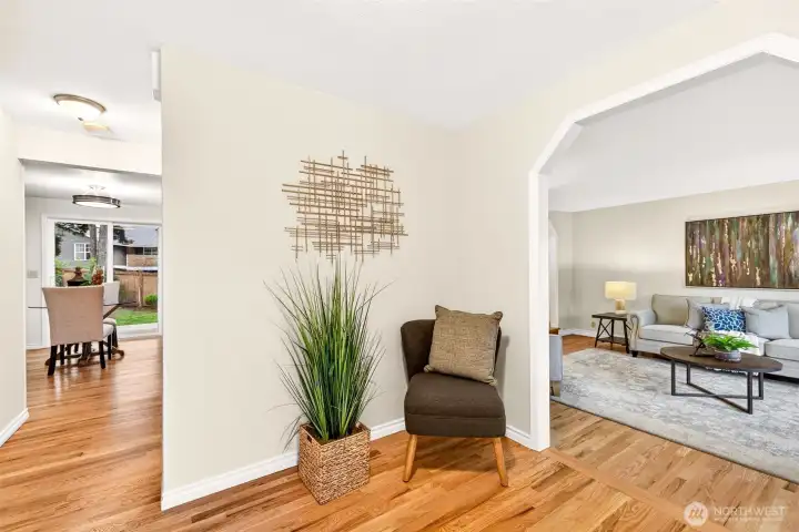 Inside, bright and welcoming spaces begin at the entry, where refinished hardwood floors help set the tone for the main level. The layout immediately feels functional and inviting, with a floorplan that balances openness and distinct living areas