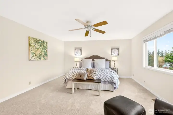 This view highlights the primary bedroom’s generous dimensions and flexible layout, with space for a full bedroom arrangement and more. The room feels calm, bright, and comfortable, with the scale buyers want in a true primary suite.