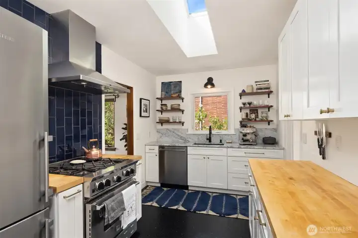 Fully updated kitchen with marble and butcher block countertops and gas range.