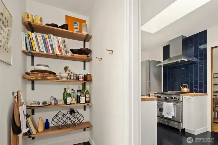 Convenient kitchen-adjacent storage alcove with built-in shelving.