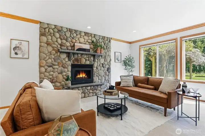 Comfortable family room is anchored by a beautiful and stunning river rock fireplace, creating a warm and inviting space.