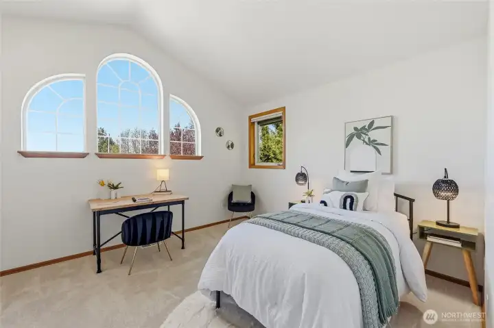 One of three generously sized upstairs guest bedrooms showcases the unique windows that enhance the homes character and charm.