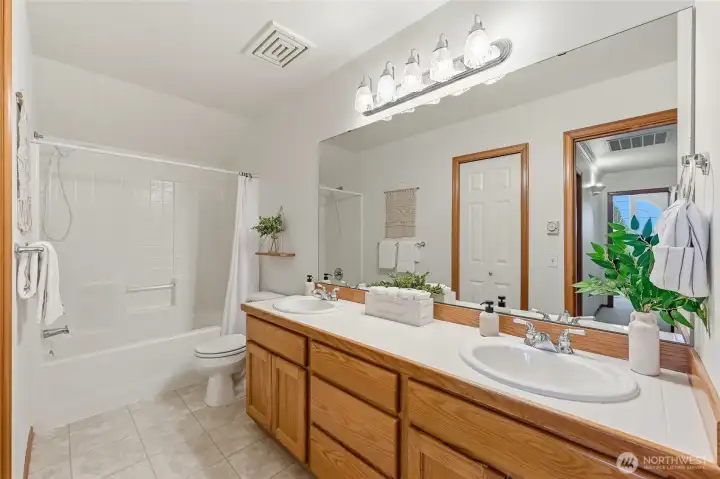 Generously sized guest bathroom with double vanity provides abundant space and functionality.