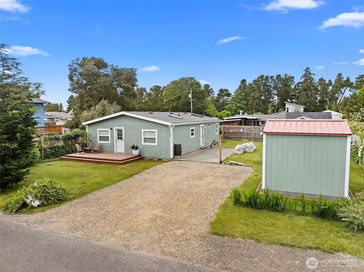 View of the home, storage shed and garden with the studio hiding behind