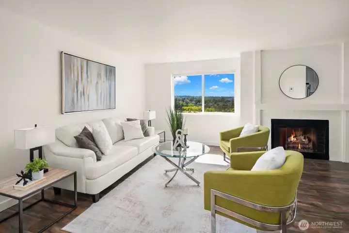 Bright and stylish living room featuring a cozy fireplace, modern finishes, and large windows that frame stunning views of the Seattle skyline and Olympic Mountains. Bright and stylish living room featuring a cozy fireplace, modern finishes, and large windows that frame stunning views of the Seattle skyline and Olympic Mountains.