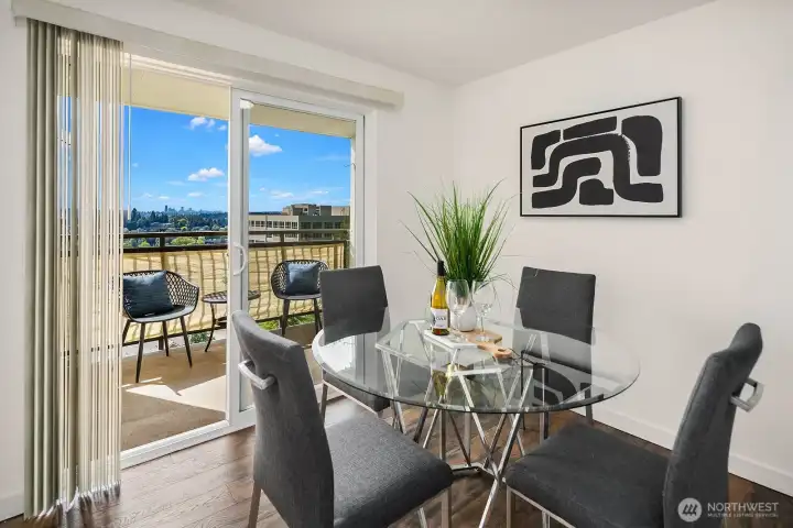 Stylish dining area with a modern glass table and direct balcony access, perfectly positioned to take in the stunning skyline and mountain views. Stylish dining area with a modern glass table and direct balcony access, perfectly positioned to take in the stunning skyline and mountain views.