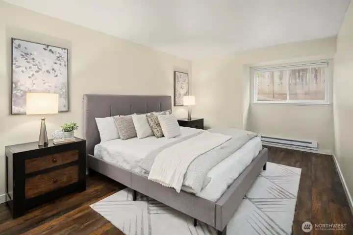 Spacious primary bedroom featuring rich hardwood floors, generous natural light, and a serene atmosphere perfect for rest and relaxation. Spacious primary bedroom featuring rich hardwood floors, generous natural light, and a serene atmosphere perfect for rest and relaxation.