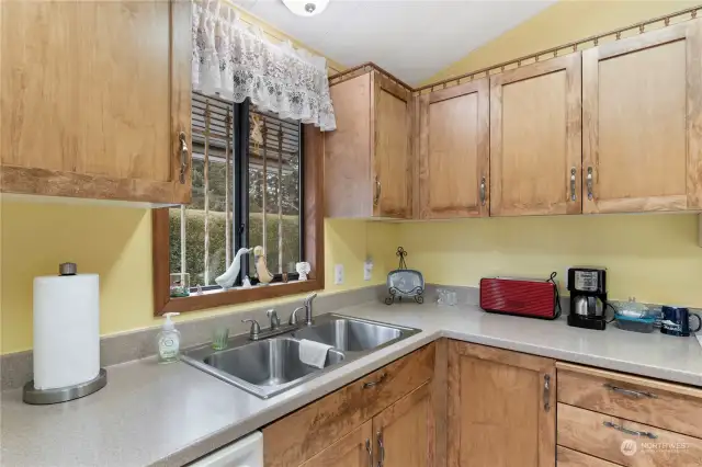 Not only is your new kitchen light and bright, with beautiful wood cabinets and Corian counters, there's loads of space to work and a private pleasant view out the kitchen window. What more could you wish for?