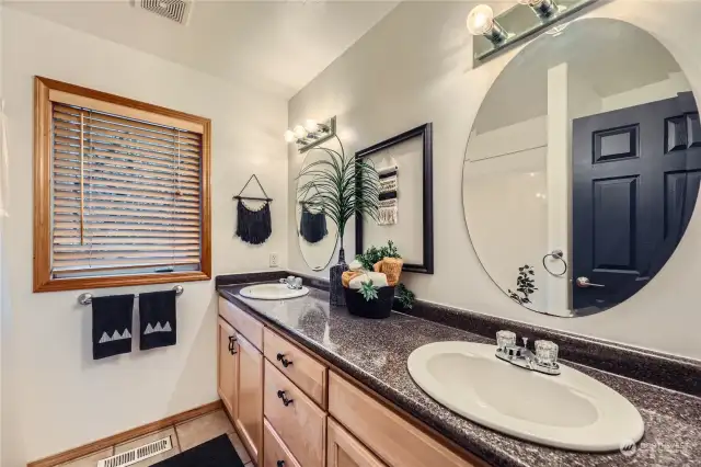 This well-appointed full bathroom features double sinks and a bright, open layout, offering both style and convenience.