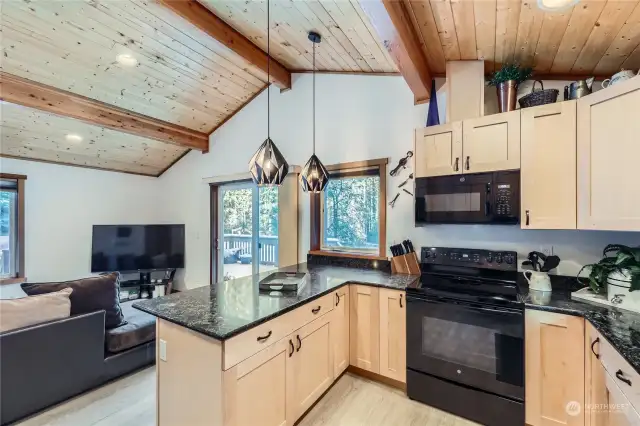 The ADU kitchen boasts granite countertops, a beautiful tile backsplash, and recessed lighting, creating a bright and inviting space for cooking and entertaining.