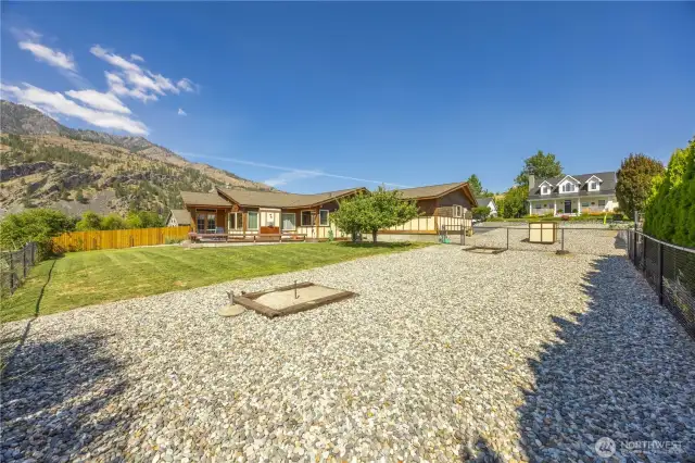 Large yard with horseshoe pit and mature fruit-bearing apple trees