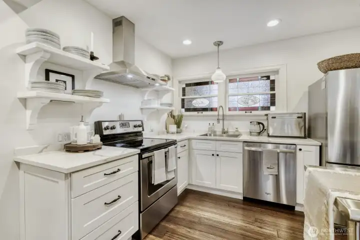 Gourmet kitchen with quartz countertops, stainless steel appliances, soft close cabinets, updated hoood